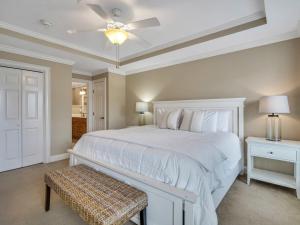 a bedroom with a white bed and a ceiling fan at Silver Seas 103 in Tybee Island +18 photos