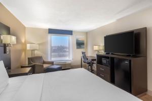 a hotel room with a bed and a flat screen tv at Best Western Plus Madison in Madison