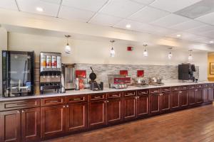 a large kitchen with wooden cabinets and a bar at Best Western Plus Madison in Madison