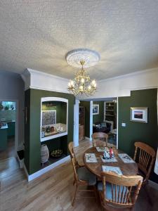 a dining room with a table and a chandelier at Peacock Cottage Eaton Road in Hough Green
