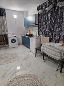 a kitchen with blue cabinets and a table and a microwave at Mary Magnolia in Craiova