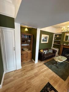 a living room with a couch and a table at Peacock Cottage Eaton Road in Hough Green