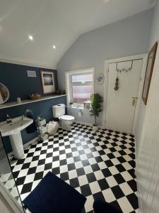 a bathroom with a black and white checkered floor at Peacock Cottage Eaton Road in Hough Green +19 photos