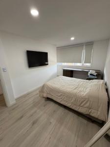 ein Schlafzimmer mit einem Bett und einem Flachbildfernseher in der Unterkunft Dúplex barrio Aeropuerto in Río Grande