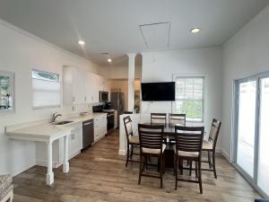 a kitchen with a table and chairs and a kitchen with white cabinets at Island Paradise in Key West
