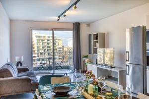 a living room with a table and a refrigerator at Elegant seafront apartment in St. Julianʼs
