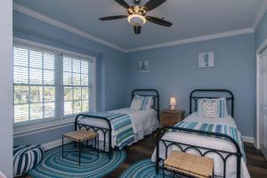a bedroom with two beds and a ceiling fan at Retreat 7B - Jubilee in Edisto Island +26 photos