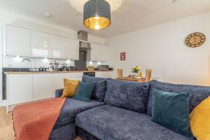 ein Wohnzimmer mit einer blauen Couch und einer Küche in der Unterkunft Hafan-Glan-Mor in Barmouth