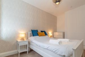 ein Schlafzimmer mit einem weißen Bett mit blauen Kissen in der Unterkunft Hafan-Glan-Mor in Barmouth