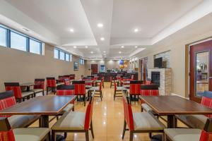 サバンナにあるComfort Suites Savannah Gateway I-95のテーブルと椅子と暖炉のあるレストラン