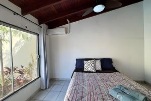 a bedroom with a bed and a large window at Casa com piscina para família em Bonito - Mato Grosso do Sul in Bonito +34 photos