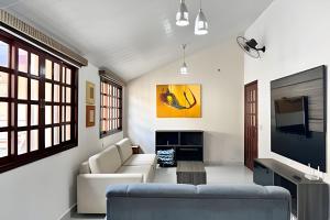 a living room with a couch and a tv at Casa com piscina para família em Bonito - Mato Grosso do Sul in Bonito