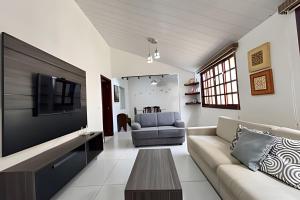 a living room with a couch and a tv at Casa com piscina para família em Bonito - Mato Grosso do Sul in Bonito