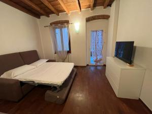 a living room with a bed and a flat screen tv at IRIS - Spaziosa Casa Indipendente in Bergamo