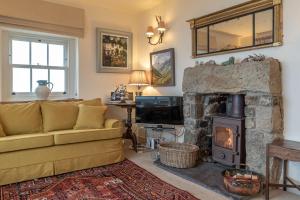 a living room with a couch and a fireplace at 2-Bryn-Tirion in Rhiw