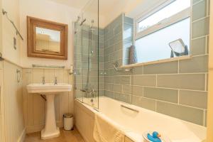 a bathroom with a sink and a bath tub and a sink at 2-Bryn-Tirion in Rhiw +27 photos