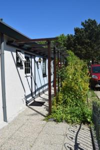 a building with awning and plants on the side of it at Kleines Haus Mit Garten, Direkt Hinter Dem Deich in Baarland