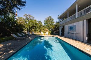 a swimming pool next to a house with a wooden deck at I'll Have Another in Edisto Island