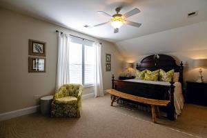 a bedroom with a bed and a chair and a ceiling fan at I'll Have Another in Edisto Island +45 photos