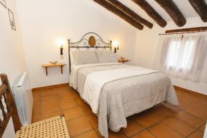 ein Schlafzimmer mit einem großen Bett mit einer weißen Tagesdecke in der Unterkunft Rural Casa Caravaca, 1º, Campo San Juan in La Risca