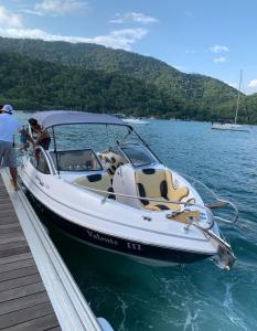 ein Boot liegt an einem Dock im Wasser in der Unterkunft Aluguel de Lancha em Angra in Angra dos Reis