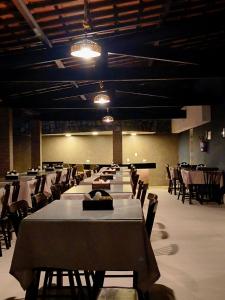 a group of tables and chairs in a large room at Hotel Três Palmeiras in Gravatá