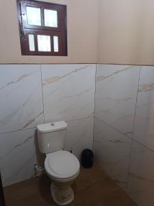 a bathroom with a toilet and a window at Sonho Meu in Itapoa