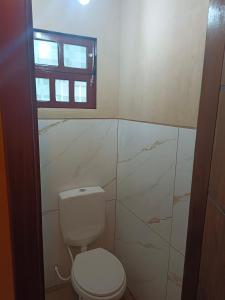a bathroom with a toilet and a window at Sonho Meu in Itapoa
