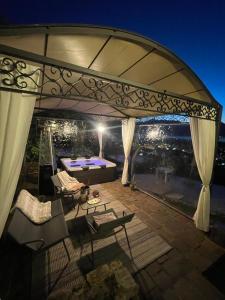 a patio with a table and chairs and an umbrella at Casa Ronco Frati, piscina vista lago in Pisogne