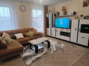 a living room with a couch and a tv at Apartament Mońki - Gold Center in Mońki