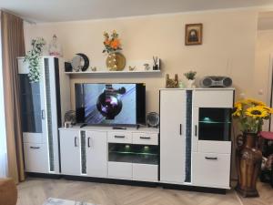 a living room with a tv in a white entertainment center at Apartament Mońki - Gold Center in Mońki +3 photos