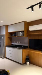 cocina con armarios blancos, fregadero y nevera en Cobertura Linear no Recreio - Varanda Grande, Vista Montanhas, Próx Praia, Garagem, Acomoda até 4 pessoas, en Río de Janeiro