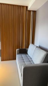 un sofá en una habitación con una pared de madera en Cobertura Linear no Recreio - Varanda Grande, Vista Montanhas, Próx Praia, Garagem, Acomoda até 4 pessoas, en Río de Janeiro 13 fotos más