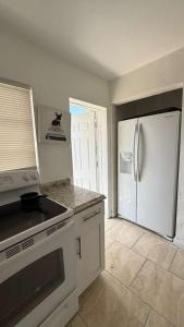 a kitchen with white appliances and a refrigerator at Hallandale Urban Rooms in Hallandale Beach +2 photos