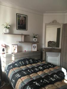 1 dormitorio con cama con edredón en Tour Eiffel, Paris Expo - Parc des Princes Apartement, en París 17 fotos más