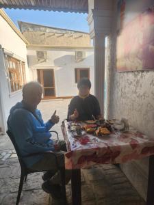 two women sitting at a table eating food at Ali Nur in Bukhara +16 photos