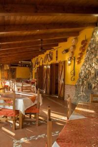 a restaurant with tables and chairs and a stone wall at Agriturismo Conca del Re in Castrovillari