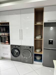a kitchen with a washing machine and a washer at 98 Inn Guesthouse Two Bedroom Apartment in Jacksonʼs Drift