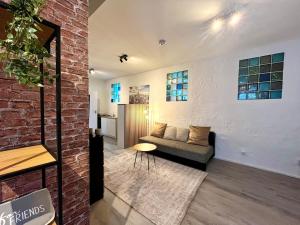 a living room with a couch and a brick wall at Industrial feeling in a quiet location in Leipzig