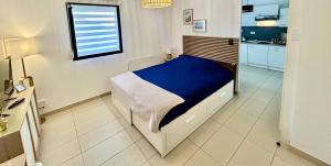 a bedroom with a bed with a blue blanket at Le Cocon des Thermes Amneville Metz Luxembourg in Amnéville