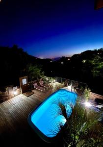 a large blue swimming pool at night at Bangalô Bambu in Imbituba