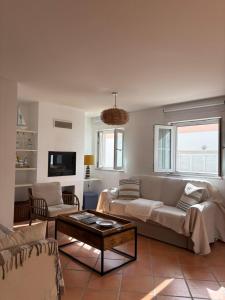 a living room with a couch and a table at Ria Seahouse Cabanas de Tavira in Tavira