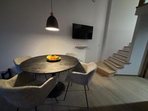 a dining room with a table and chairs with a bowl of fruit at Le Marzelheide 2 in Lontzen