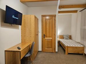 a room with a desk and a bed and a television at Miętusi Dwór in Zakopane