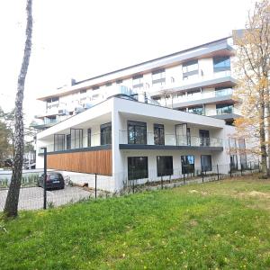 a white building with a car parked in front of it at Baltic Jet Silver Sea in Ustronie Morskie