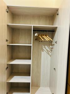 a walk in closet with wooden shelves at رغدان فيو للشقق المخدومة in Al Baha