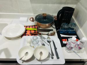 a table with plates and utensils on a white tray at رغدان فيو للشقق المخدومة in Al Baha