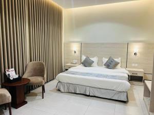 a hotel room with a bed and a chair at رغدان فيو للشقق المخدومة in Al Baha