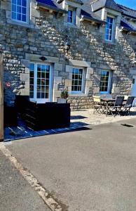 una casa de piedra con dos sillas delante en gîte en campagne Lamégritnière, en Mégrit
