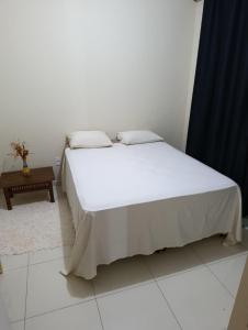 a white bed in a room with a table at Apartmento duplex in Araxá